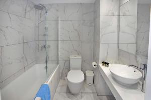 a white bathroom with a toilet and a sink at Nissiana Hotel & Bungalows in Ayia Napa