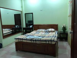 a bedroom with a bed and a large mirror at Nhà nghỉ An Phú in Hanoi
