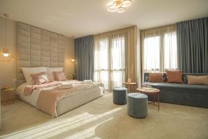 Boutique Apartments Blagoevgrad في بلاغويفغراد: غرفة نوم بسرير كبير وأريكة
