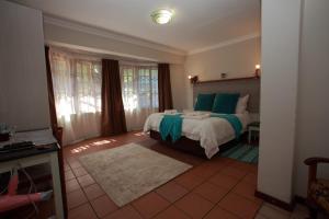 a bedroom with a large bed with blue pillows at Kaapsche Hoop Gastehuis in Kaapsehoop