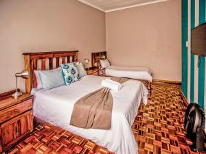 a bedroom with two beds in a room at The Russel Guest House in Port Elizabeth