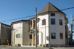 un edificio en la esquina de una calle con un semáforo en Ise Guest House Kazami, en Ise