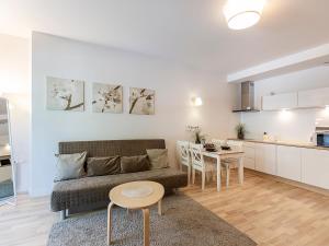 ein Wohnzimmer mit einem Sofa und einem Tisch in der Unterkunft VacationClub - Bałtycka 10 Apartament 9 in Świnoujście