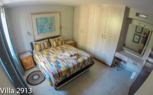 a small bedroom with a bed and a mirror at San Lameer Villas Three Bedroom --&-- Two Bedroom in Southbroom +19 photos