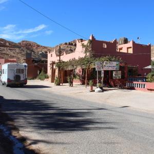 a street in a small town with a truck driving down the street at Hotel Cascades Dades in Aït Ben Ali