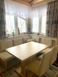 una mesa y sillas en una habitación con ventanas en Haus Langegger Resi, en Wagrain