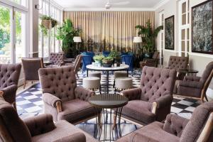 a lobby with couches and tables and chairs at Mount Nelson, A Belmond Hotel, Cape Town in Cape Town