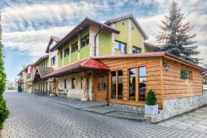 a building on a cobblestone street with a house at Zajazd Beskidy in Żywiec
