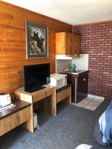 cocina con TV y escritorio con microondas en Alpine motel, en Rocky Mountain House