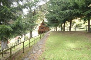 a fence in front of a house on a hill at Cabañas Lago Elizalde in Coihaique