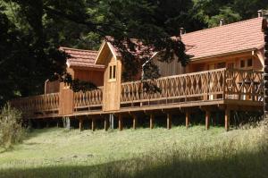 una casa de madera con una valla en un campo en Cabañas Lago Elizalde, en Coyhaique