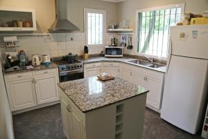 Una cocina con electrodomésticos blancos y un refrigerador blanco. en Torcazas, en San Carlos de Bariloche