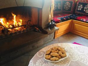 a table with a plate of donuts in front of a fireplace at Hotel Anax in Metsovo