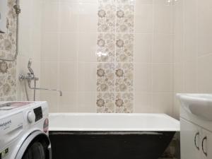 トゥーラにあるInndays on Prospekt Lenina 86のバスルーム(バスタブ、シャワー、洗濯機付)