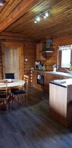 Glenmhor Log Cabin في فورت ويليام: مطبخ مع طاولة وكراسي في كابينة