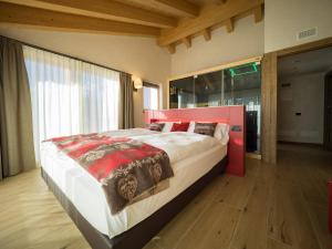 a bedroom with a large bed with a red headboard at Chalet La Dolce Vita MyHoliday in Livigno