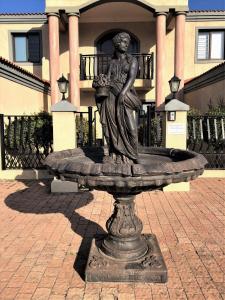 a statue of a woman sitting on top of a fountain at Swanepoel Guesthouse in Jeffreys Bay +24 photos