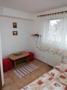 ein Wohnzimmer mit einem Tisch und einem Fenster in der Unterkunft Penzión Koruna in Nitrianske Rudno