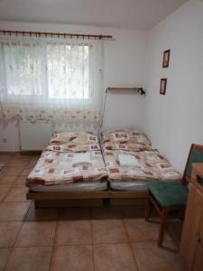 ein Schlafzimmer mit einem Bett, einem Stuhl und einem Fenster in der Unterkunft Penzión Koruna in Nitrianske Rudno