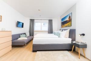 a bedroom with a bed and a couch at Easy Living Apartment Ötztal in Sautens