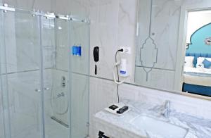 a white bathroom with a shower and a sink at KRALICE HOTEL in Istanbul