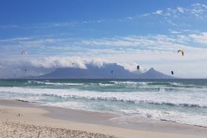 a group of people flying kites on the beach at 180 Eden on the Bay, Big Bay in Big Bay