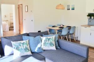 a living room with a blue couch and a table at Millbank Cottage in Blairgowrie