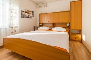 sypialnia z dużym łóżkiem z drewnianym zagłówkiem w obiekcie Ivanka 1 w mieście Selce