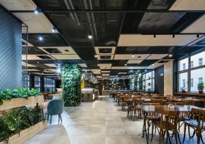 un restaurante con mesas, sillas y plantas en Ibis Praha Wenceslas Square, en Praga