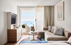 a living room with a couch and a tv at Nobu Hotel Ibiza Bay in Talamanca