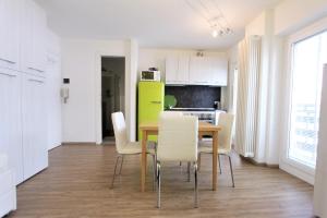 een keuken en eetkamer met een tafel en stoelen bij Hostdomus - Green Tech Apartment in Sestriere