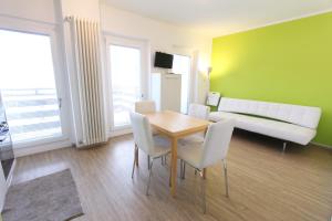 een woonkamer met een tafel en stoelen en een bank bij Hostdomus - Green Tech Apartment in Sestriere
