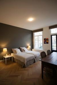 1 dormitorio con 1 cama grande y 1 mesa en Oranjepark, en Dordrecht