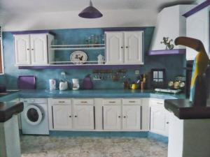 a kitchen with white cabinets and a washing machine at Maison d'hôte "Les Bougainvillées" in Port-Louis