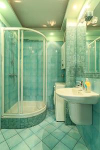 a blue bathroom with a shower and a sink at Pokoje gościnne Częstochowa in Częstochowa