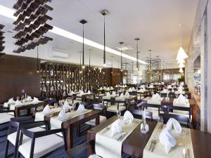 コウォブジェクにあるVacationClub - Sand Hotel★★★★ Apartament 5の木製テーブルと白い椅子とテーブルサーチャー付きのレストラン