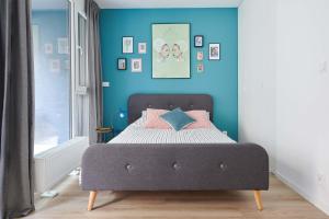 - une chambre dotée d'un lit avec un mur bleu dans l'établissement Mint Apartment, à Poznań
