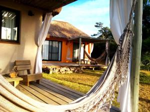 a house with a hammock in front of it at Aloha Village in La Pedrera