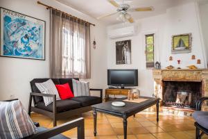 a living room with a couch and a fireplace at Bee's Knees Retreat in Pesádha