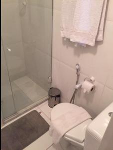 y baño blanco con ducha y aseo. en Bahia Flat Apt 124 Farol da Barra, en Salvador