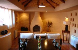 uma sala de jantar com uma mesa e uma lareira em Los Colorados Cabañas Boutique em Purmamarca