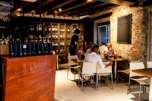 un groupe de personnes assises à des tables dans une cave à vin dans l'établissement Piccolo Tiepolo, à Venise