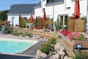 a house with a swimming pool and red umbrellas at les salines de la turballe in La Turballe