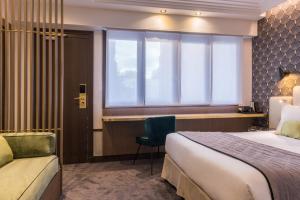 a hotel room with a bed and a desk and a window at Best Western Select Hotel in Boulogne-Billancourt