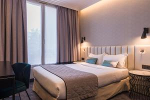 a hotel room with a bed and a large window at Best Western Select Hotel in Boulogne-Billancourt
