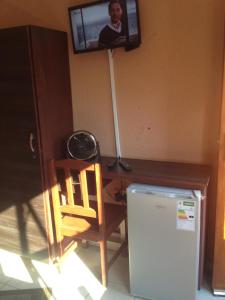 a tv hanging on a wall above a refrigerator at FGM Guesthouse 2 in Alberton +11 photos