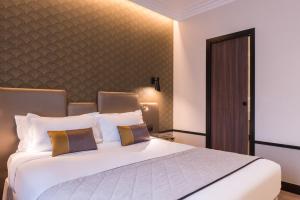 a bedroom with a large white bed with pillows at Best Western Select Hotel in Boulogne-Billancourt