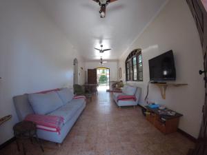 a living room with a couch and a tv at Bertioga Beach Hostel in Bertioga