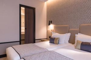 a bedroom with a large bed with white sheets and pillows at Best Western Select Hotel in Boulogne-Billancourt