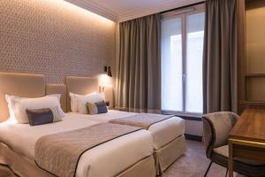 a hotel room with two beds and a desk at Best Western Select Hotel in Boulogne-Billancourt